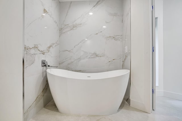 bathroom featuring a tub and tile walls