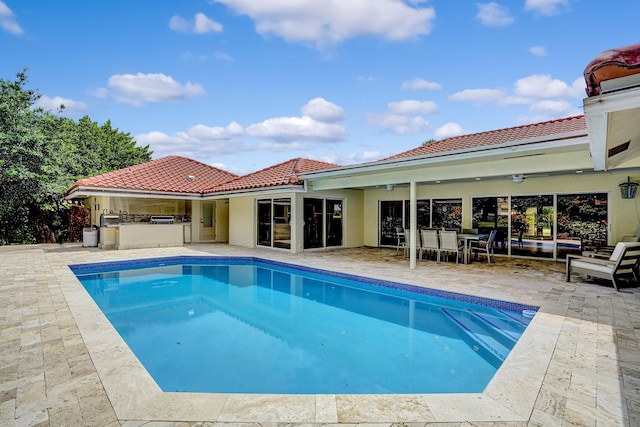 view of pool with a patio area and exterior kitchen