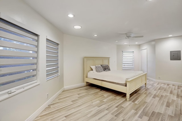 bedroom with light wood-type flooring, electric panel, and ceiling fan