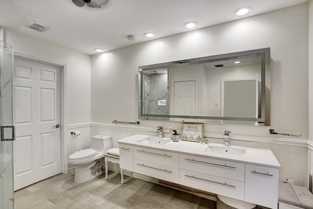 bathroom with vanity, toilet, and a shower with door