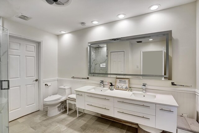 4246 Live Oak Blvd, Delray Beach, FL 33445 - bathroom featuring a wainscoted wall, a stall shower, double vanity, and toilet