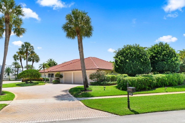 4246 Live Oak Blvd, Delray Beach, FL 33445 - mediterranean / spanish-style house featuring a garage, a tiled roof, decorative driveway, a front yard, and stucco siding