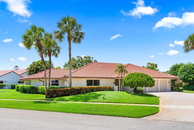 4246 Live Oak Blvd, Delray Beach, FL 33445 - view of front of home featuring a tile roof, decorative driveway, a front lawn, and an attached garage