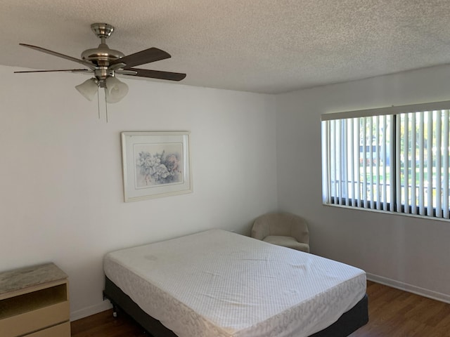 bedroom with a textured ceiling, dark hardwood / wood-style floors, and ceiling fan