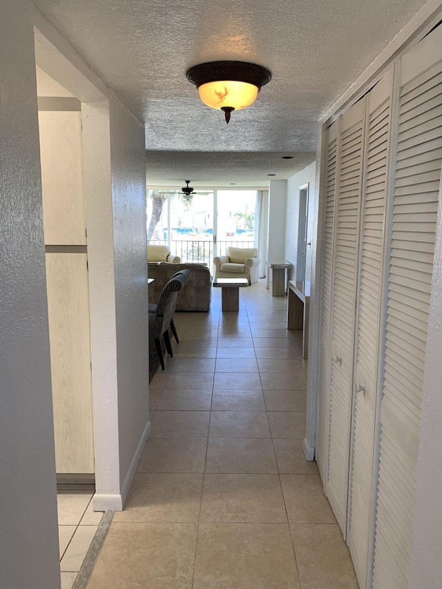 hall with light tile patterned floors and a textured ceiling