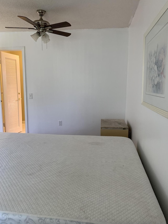 bedroom featuring ceiling fan and a textured ceiling