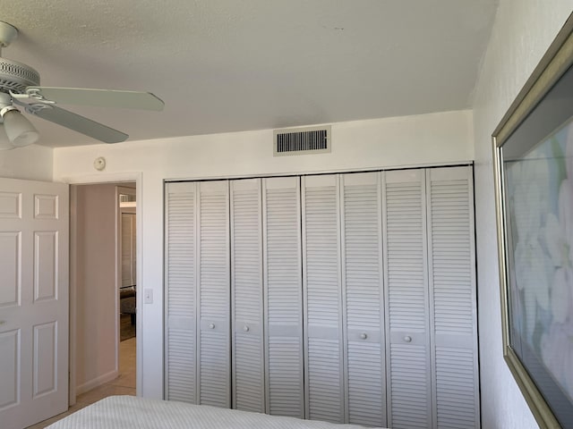 unfurnished bedroom with ceiling fan and a closet