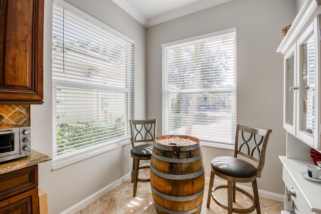 sitting room with light tile patterned floors and crown molding