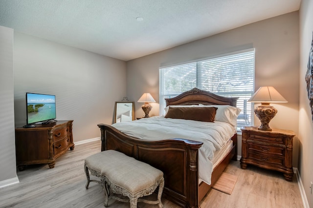 bedroom with light wood-type flooring and a textured ceiling