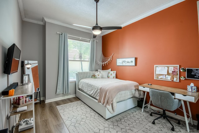 bedroom featuring ceiling fan, crown molding, wood-type flooring, and a textured ceiling