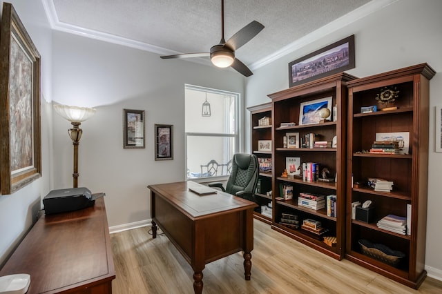 office featuring ceiling fan, light wood-type flooring, a textured ceiling, and ornamental molding