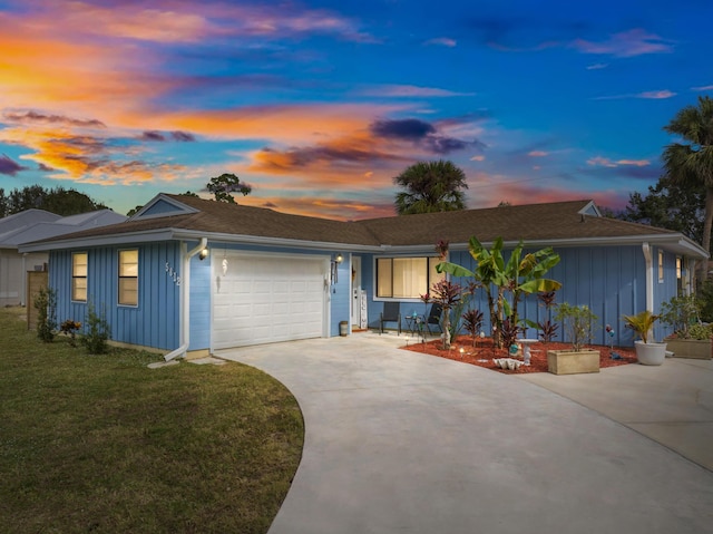 single story home with a lawn and a garage