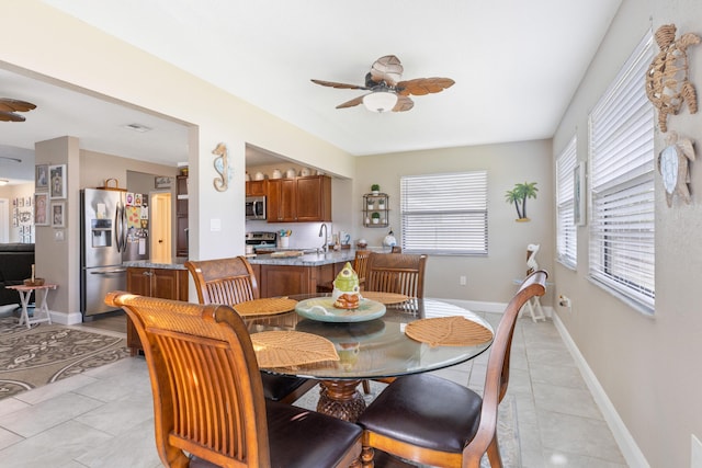 dining room with light tile patterned floors, ceiling fan, and sink