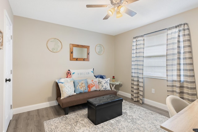 living area with ceiling fan and wood-type flooring