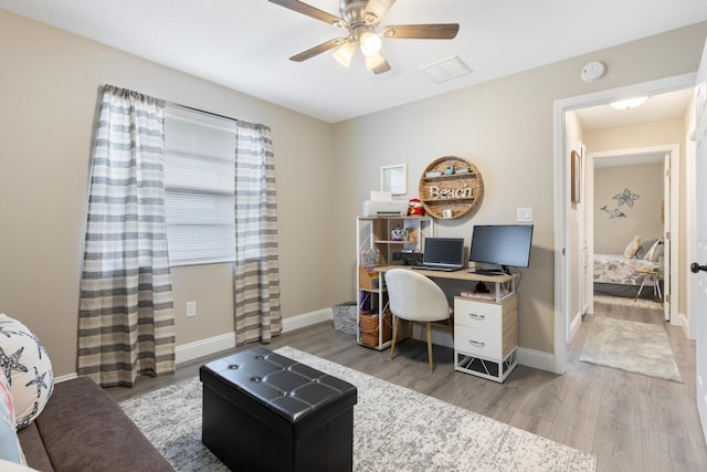 office with light hardwood / wood-style floors and ceiling fan