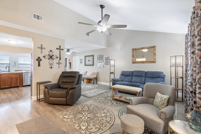 living room featuring ceiling fan, lofted ceiling, sink, and light hardwood / wood-style flooring