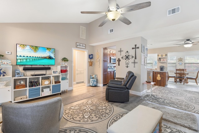 living room with hardwood / wood-style floors, vaulted ceiling, and ceiling fan