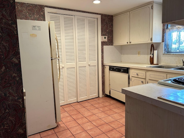 kitchen featuring light tile patterned flooring and white appliances