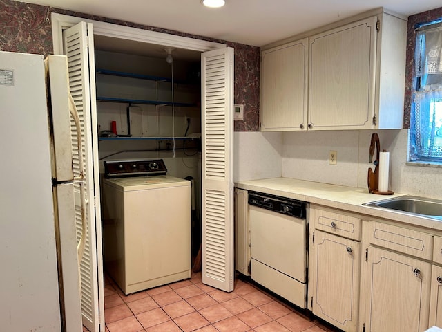 kitchen featuring washer / clothes dryer, sink, light tile patterned floors, and white appliances