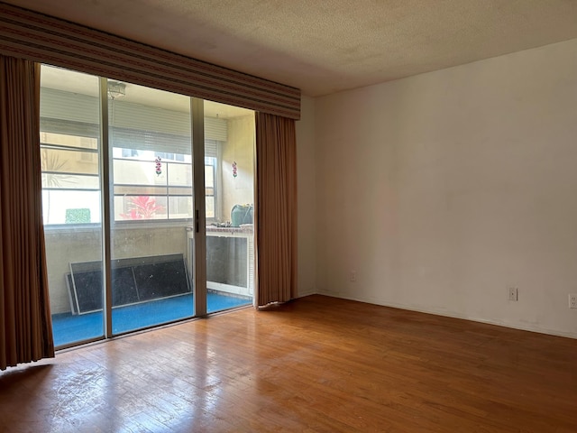 unfurnished room featuring a textured ceiling and hardwood / wood-style flooring