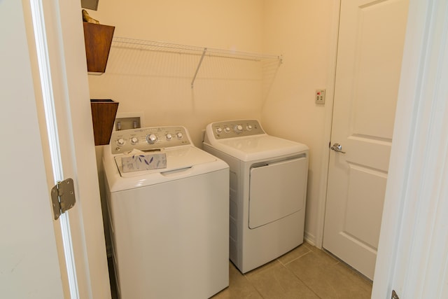 clothes washing area with light tile patterned floors and separate washer and dryer