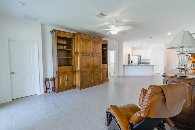 living room featuring light tile patterned flooring and ceiling fan