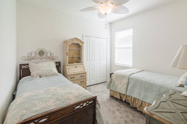 bedroom featuring light colored carpet, a closet, and ceiling fan