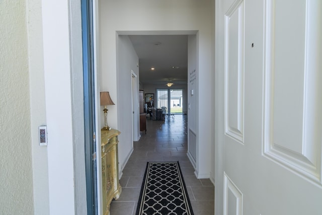 hallway featuring dark tile patterned floors