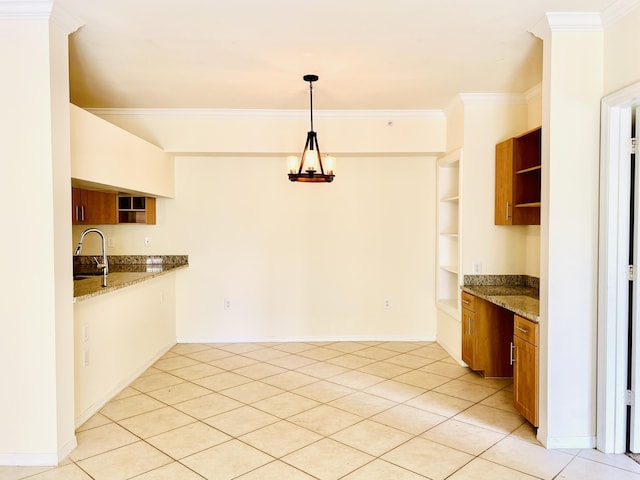 kitchen with sink, hanging light fixtures, light stone counters, light tile patterned floors, and ornamental molding