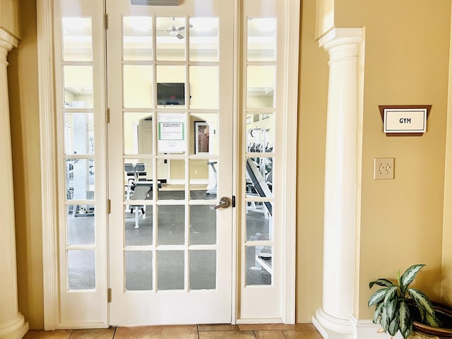 entryway featuring tile patterned floors and ornate columns