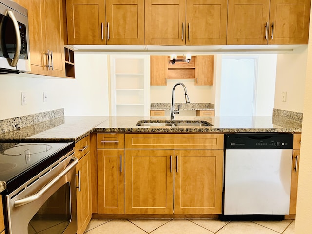 kitchen with light tile patterned floors, stainless steel appliances, light stone counters, and sink