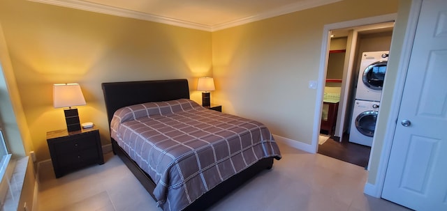 bedroom featuring crown molding and stacked washer and clothes dryer