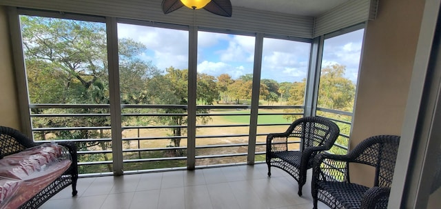 sunroom / solarium featuring plenty of natural light and ceiling fan