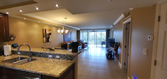 kitchen featuring stainless steel dishwasher, crown molding, light stone counters, and sink