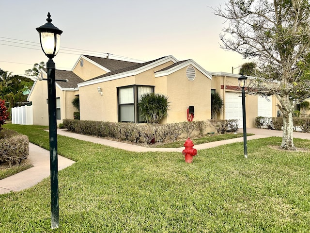 ranch-style house with a garage and a yard