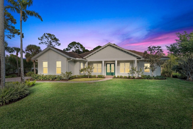 ranch-style house featuring a yard and french doors