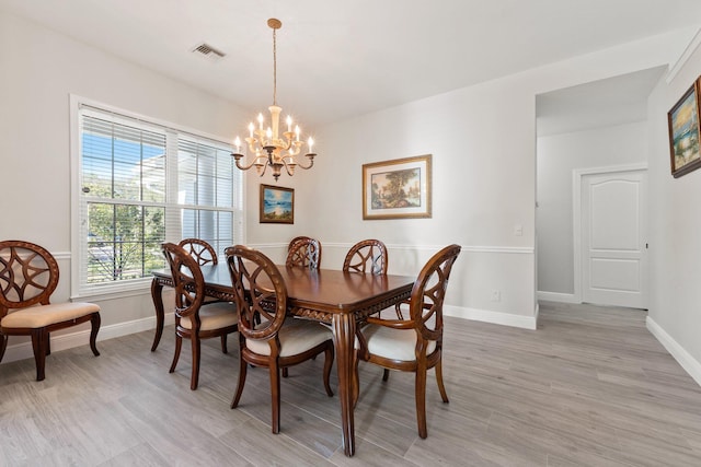 dining area with a chandelier and light hardwood / wood-style floors