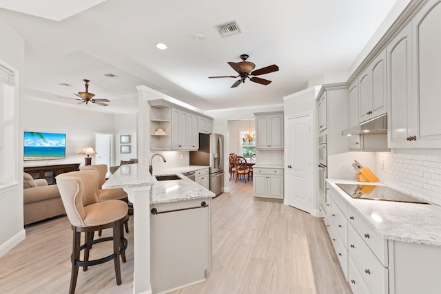 kitchen with kitchen peninsula, backsplash, stainless steel appliances, and sink