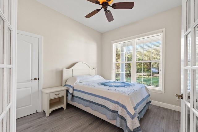 bedroom with hardwood / wood-style floors, multiple windows, and ceiling fan