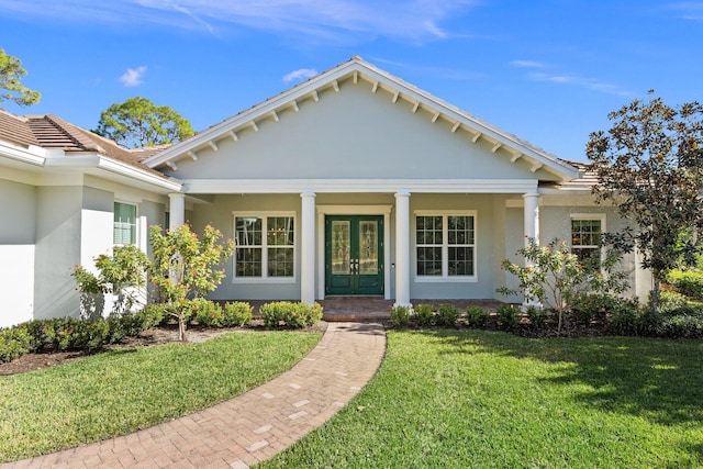 view of front of property with french doors and a front lawn