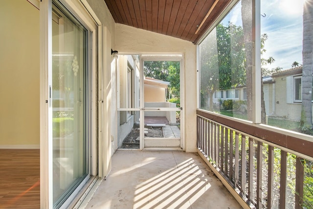 unfurnished sunroom featuring wooden ceiling and vaulted ceiling