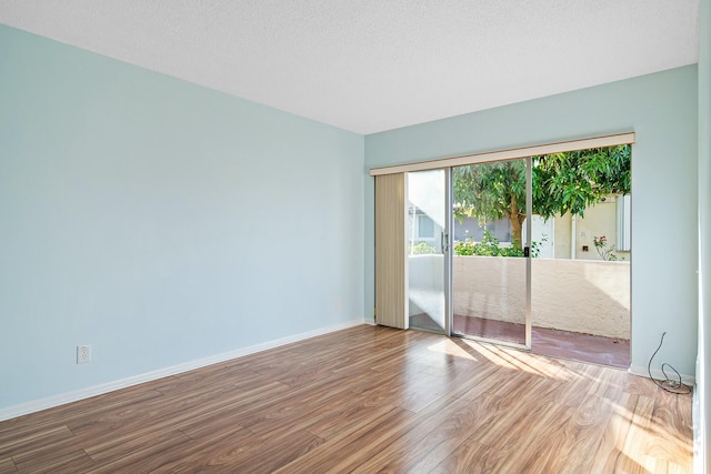 unfurnished room featuring hardwood / wood-style floors and a textured ceiling