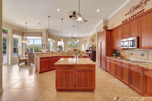 kitchen featuring a large island, stainless steel microwave, a ceiling fan, paneled refrigerator, and black electric cooktop