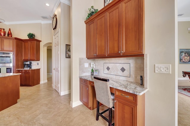 kitchen with arched walkways, light stone counters, stainless steel double oven, tasteful backsplash, and crown molding