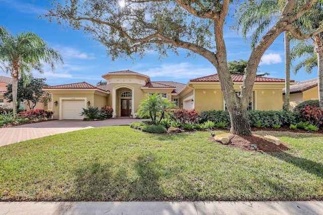 mediterranean / spanish house featuring a garage and a front yard