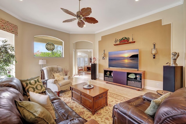 living area with ornamental molding, arched walkways, and a healthy amount of sunlight