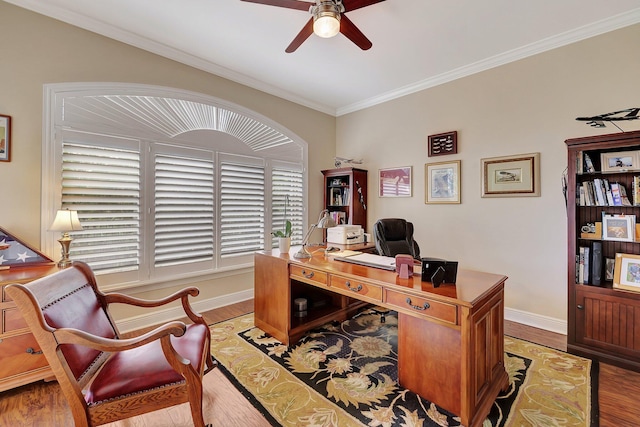 office featuring a ceiling fan, ornamental molding, baseboards, and wood finished floors