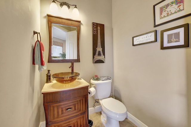 bathroom with vanity, toilet, and baseboards