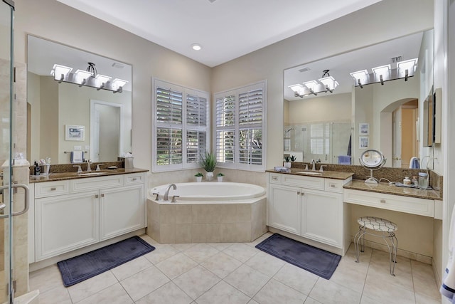 bathroom with a stall shower, tile patterned flooring, a sink, and a bath