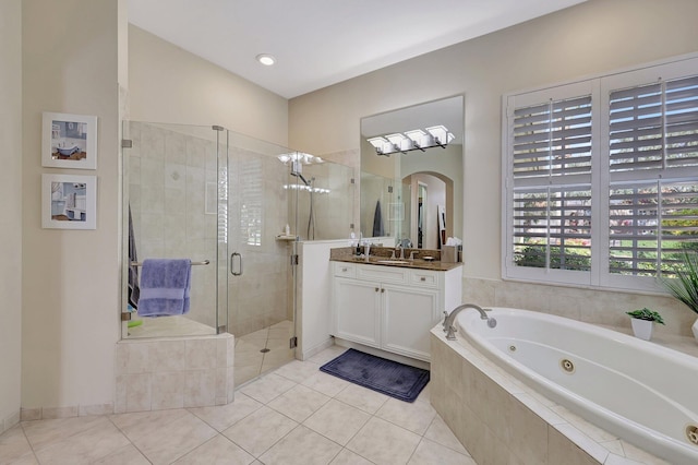 bathroom with a whirlpool tub, a stall shower, tile patterned floors, and vanity